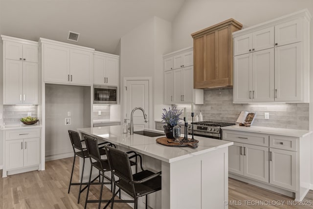 5109 S Everett Dr, Sand Springs, OK 74063 - kitchen featuring built in microwave, a sink, backsplash, stainless steel gas stove, and white cabinets