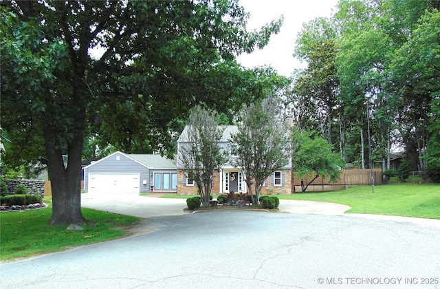 2619 E 47th St, Tulsa, OK 74105 - view of front facade with concrete driveway, an attached garage, and stone siding
