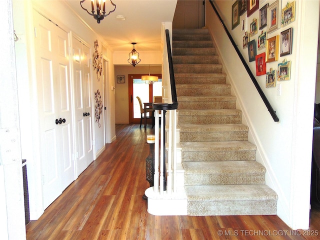 2619 E 47th St, Tulsa, OK 74105 - stairway featuring wood finished floors, crown molding, baseboards, and a chandelier