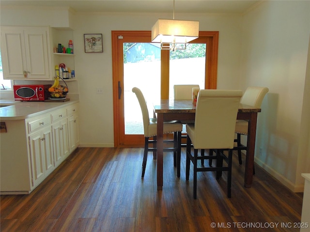 2619 E 47th St, Tulsa, OK 74105 - dining room featuring dark wood-style floors, ornamental molding, baseboards, and a chandelier