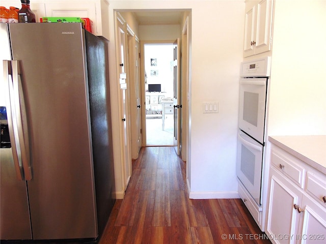 2619 E 47th St, Tulsa, OK 74105 - kitchen with stainless steel fridge with ice dispenser, white double oven, dark wood-style flooring, and white cabinets