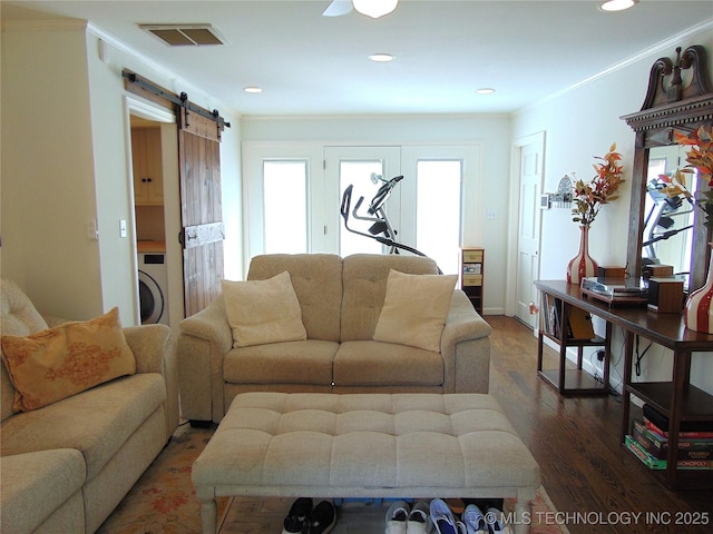 2619 E 47th St, Tulsa, OK 74105 - living area featuring healthy amount of natural light, a barn door, washer / dryer, wood finished floors, and crown molding