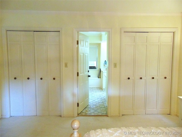 2619 E 47th St, Tulsa, OK 74105 - unfurnished bedroom featuring crown molding and multiple closets