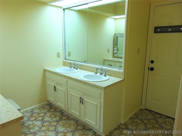 2619 E 47th St, Tulsa, OK 74105 - full bathroom with double vanity, tile patterned floors, and baseboards