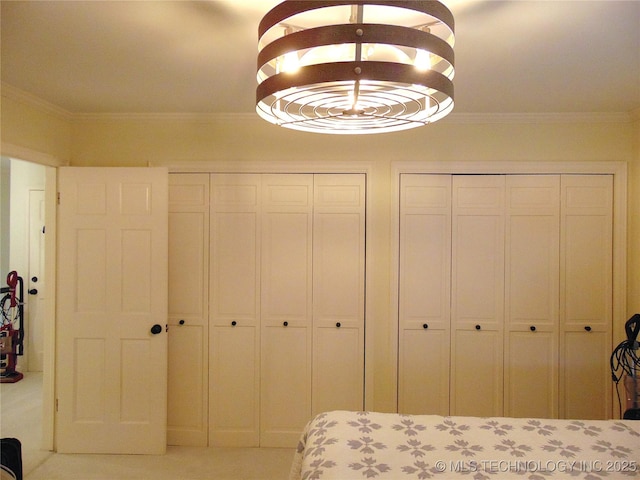 2619 E 47th St, Tulsa, OK 74105 - bedroom featuring two closets, ornamental molding, and carpet