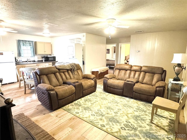 421224 E 1165th Rd, Eufaula, OK 74432 - living area with a ceiling fan, light wood finished floors, and a textured ceiling