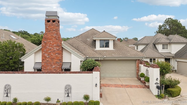 4817 S Yorktown Pl, Tulsa, OK 74105 - view of front of house featuring concrete driveway, a garage, stucco siding, and a chimney