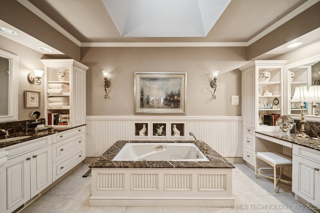 4817 S Yorktown Pl, Tulsa, OK 74105 - bathroom with a tub with jets, vanity, a wainscoted wall, ornamental molding, and tile patterned floors