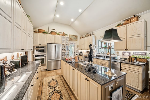4817 S Yorktown Pl, Tulsa, OK 74105 - kitchen with appliances with stainless steel finishes, an island with sink, dark stone counters, high vaulted ceiling, and a sink