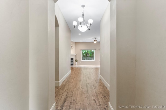 4675 E 144th Pl S, Bixby, OK 74008 - corridor with light wood-style floors, a chandelier, arched walkways, baseboards, and recessed lighting