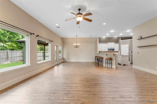 4675 E 144th Pl S, Bixby, OK 74008 - living area with light wood finished floors, ceiling fan, a chandelier, baseboards, and recessed lighting