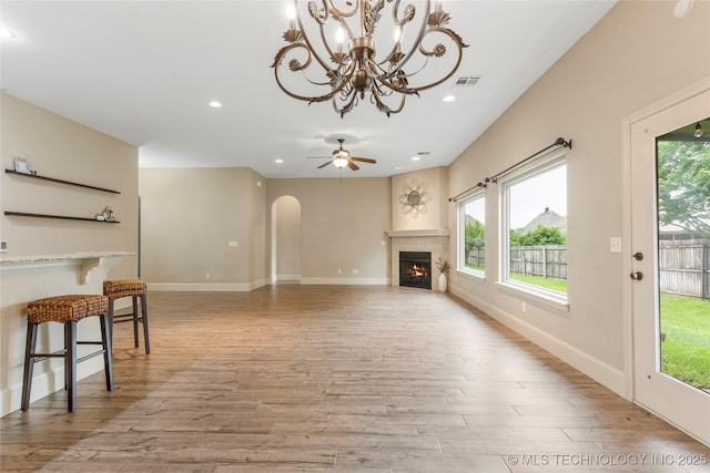 4675 E 144th Pl S, Bixby, OK 74008 - unfurnished living room with light wood-style flooring, arched walkways, healthy amount of natural light, recessed lighting, and ceiling fan