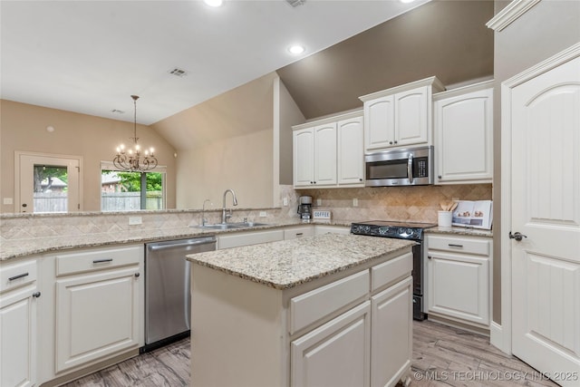 4675 E 144th Pl S, Bixby, OK 74008 - kitchen featuring appliances with stainless steel finishes, a sink, light wood-type flooring, lofted ceiling, and tasteful backsplash