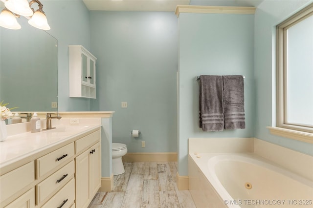 4675 E 144th Pl S, Bixby, OK 74008 - bathroom featuring vanity, a tub with jets, toilet, baseboards, and wood finished floors