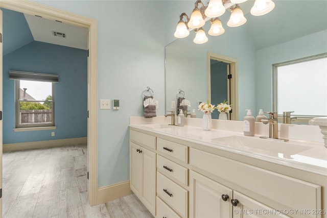 4675 E 144th Pl S, Bixby, OK 74008 - full bathroom featuring vaulted ceiling, double vanity, wood finished floors, a chandelier, and baseboards
