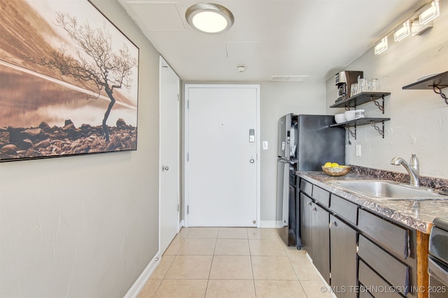 410 W 7th St Unit 1230, Tulsa, OK 74119 - kitchen featuring a sink, freestanding refrigerator, open shelves, light tile patterned floors, and baseboards