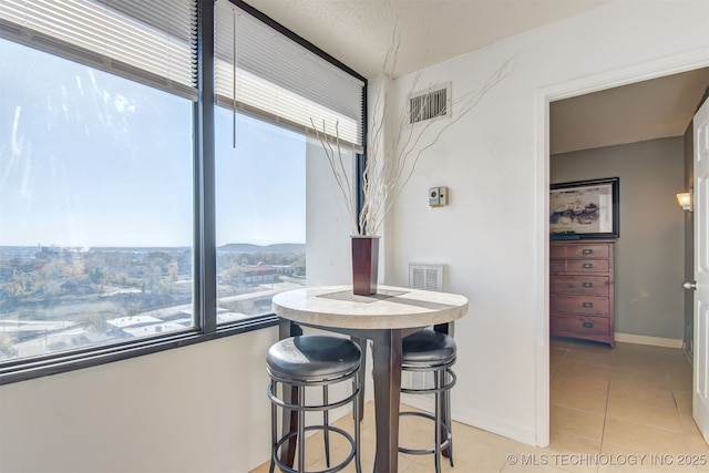 410 W 7th St Unit 1230, Tulsa, OK 74119 - dining room featuring healthy amount of natural light, light tile patterned flooring, and baseboards