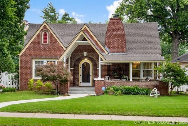 2403 S Troost Ave, Tulsa, OK 74114 - tudor home featuring brick siding, a chimney, and a shingled roof