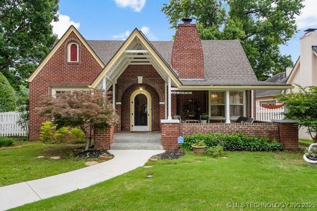 2403 S Troost Ave, Tulsa, OK 74114 - english style home featuring brick siding, a chimney, and a shingled roof