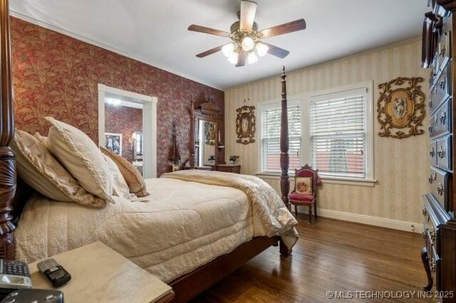 2403 S Troost Ave, Tulsa, OK 74114 - bedroom with wallpapered walls, wood finished floors, baseboards, and ceiling fan
