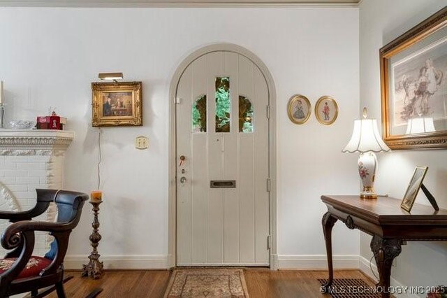 2403 S Troost Ave, Tulsa, OK 74114 - entryway with baseboards, arched walkways, and wood finished floors