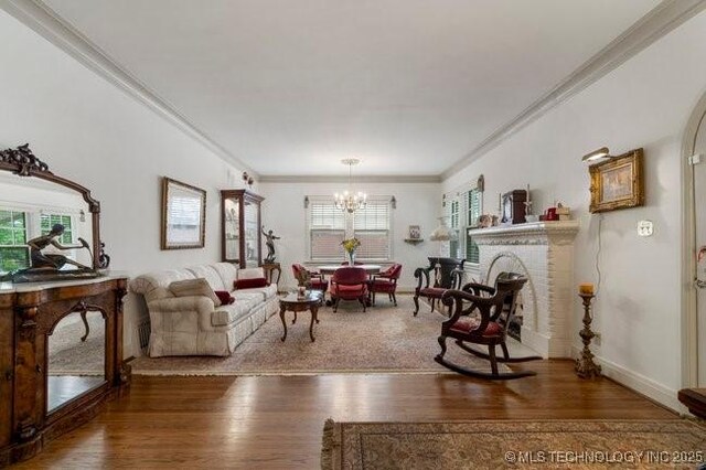 2403 S Troost Ave, Tulsa, OK 74114 - living room featuring healthy amount of natural light, a chandelier, ornamental molding, and wood finished floors