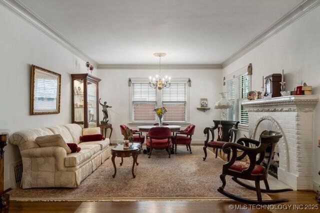 2403 S Troost Ave, Tulsa, OK 74114 - living area with a chandelier, crown molding, wood finished floors, a brick fireplace, and baseboards