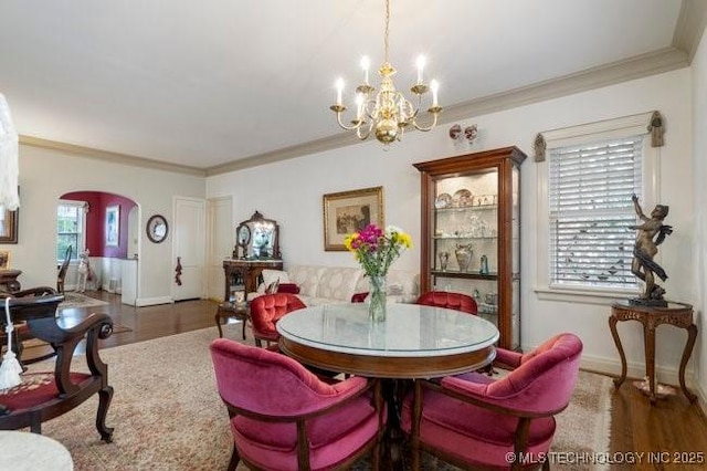 2403 S Troost Ave, Tulsa, OK 74114 - dining space featuring wood finished floors, arched walkways, a chandelier, ornamental molding, and baseboards