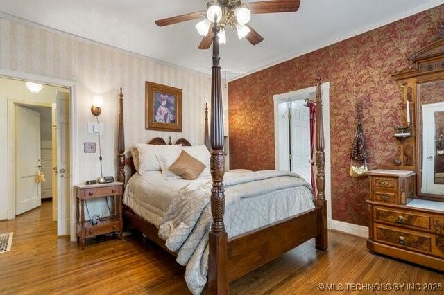 2403 S Troost Ave, Tulsa, OK 74114 - bedroom featuring wallpapered walls, wood finished floors, baseboards, crown molding, and ceiling fan