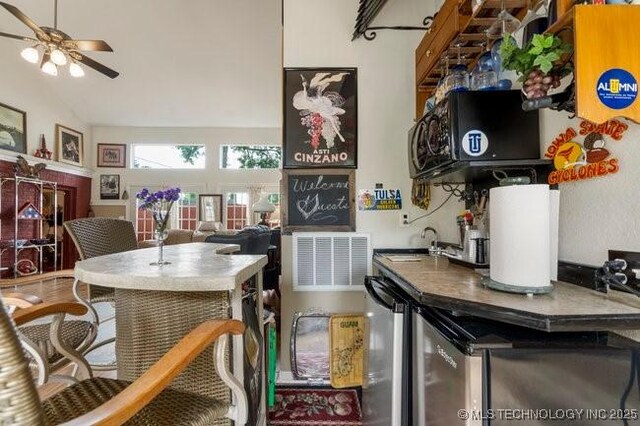 2403 S Troost Ave, Tulsa, OK 74114 - kitchen with ceiling fan, lofted ceiling, a sink, and refrigerator