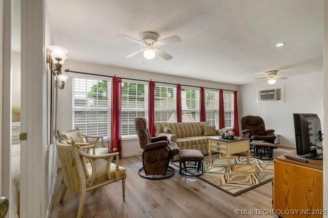 2403 S Troost Ave, Tulsa, OK 74114 - living area with a ceiling fan, an AC wall unit, and wood finished floors