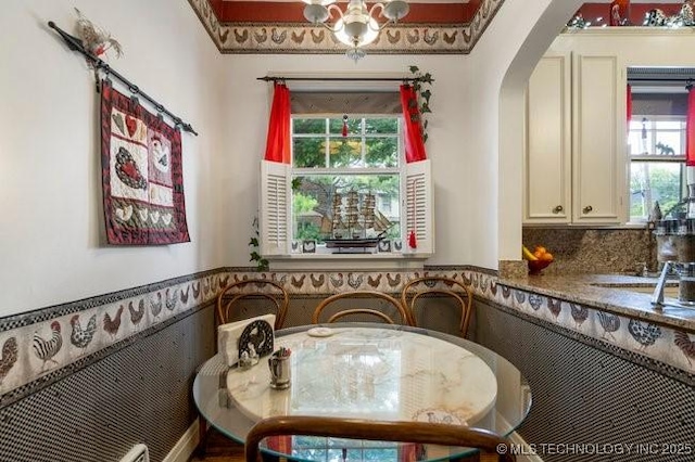 2403 S Troost Ave, Tulsa, OK 74114 - dining room featuring arched walkways and a wainscoted wall