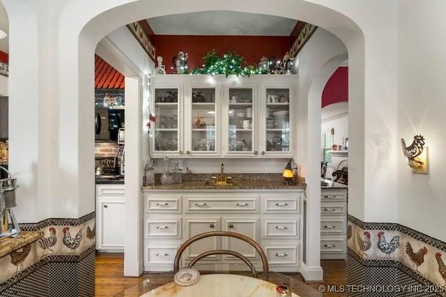 2403 S Troost Ave, Tulsa, OK 74114 - indoor wet bar featuring wood finished floors and arched walkways