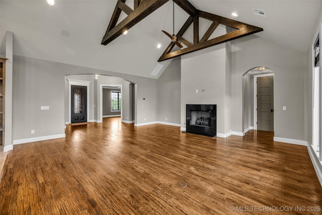 3805 S Tamarack Ave, Broken Arrow, OK 74011 - unfurnished living room with high vaulted ceiling, a fireplace, beam ceiling, baseboards, and arched walkways