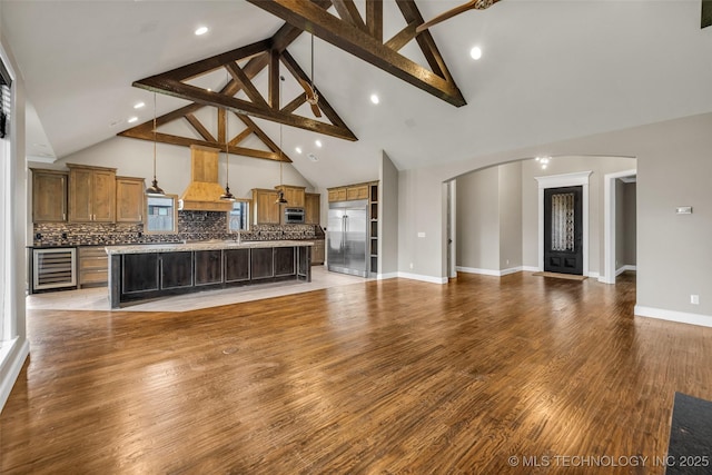3805 S Tamarack Ave, Broken Arrow, OK 74011 - living area featuring wine cooler, high vaulted ceiling, arched walkways, beam ceiling, and light wood-style floors