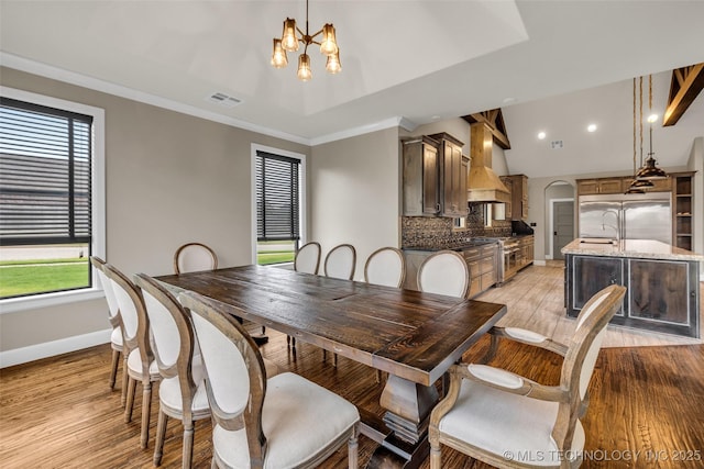 3805 S Tamarack Ave, Broken Arrow, OK 74011 - dining space featuring a chandelier, baseboards, light wood-style floors, arched walkways, and recessed lighting