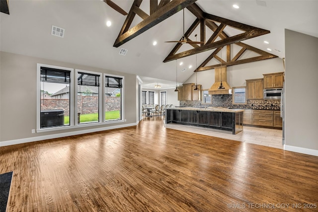 3805 S Tamarack Ave, Broken Arrow, OK 74011 - living area featuring high vaulted ceiling, healthy amount of natural light, beamed ceiling, light wood-style flooring, and baseboards