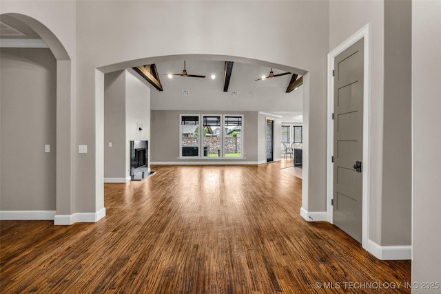 3805 S Tamarack Ave, Broken Arrow, OK 74011 - unfurnished living room with ceiling fan, wood finished floors, baseboards, and beamed ceiling