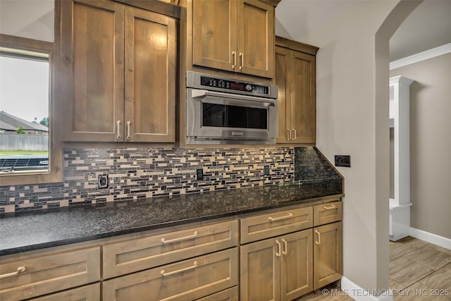3805 S Tamarack Ave, Broken Arrow, OK 74011 - kitchen featuring arched walkways, oven, backsplash, and baseboards