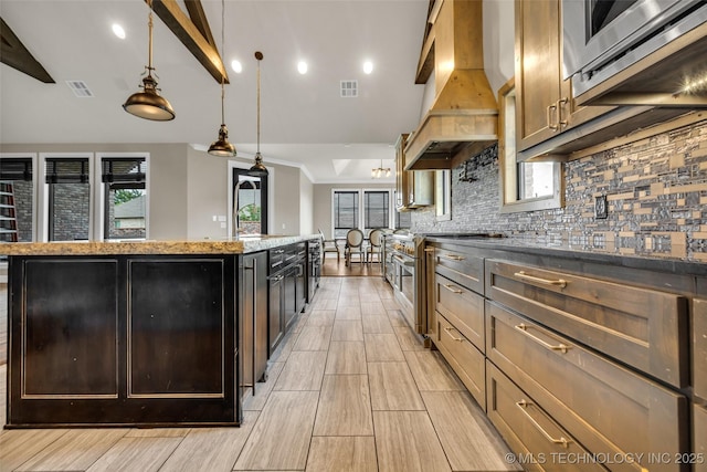 3805 S Tamarack Ave, Broken Arrow, OK 74011 - kitchen featuring island exhaust hood, a kitchen island, backsplash, light stone counters, and hanging light fixtures