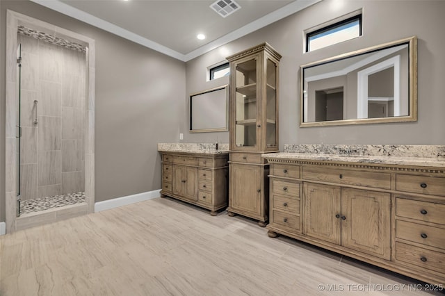 3805 S Tamarack Ave, Broken Arrow, OK 74011 - full bathroom featuring two vanities, tiled shower, baseboards, crown molding, and plenty of natural light