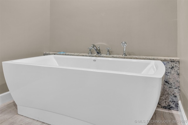 3805 S Tamarack Ave, Broken Arrow, OK 74011 - bathroom with a freestanding bath, baseboards, and wood finished floors