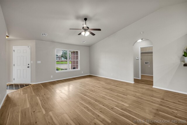 9220 S 256th E Ave, Broken Arrow, OK 74014 - unfurnished living room featuring lofted ceiling, a ceiling fan, light wood finished floors, baseboards, and arched walkways