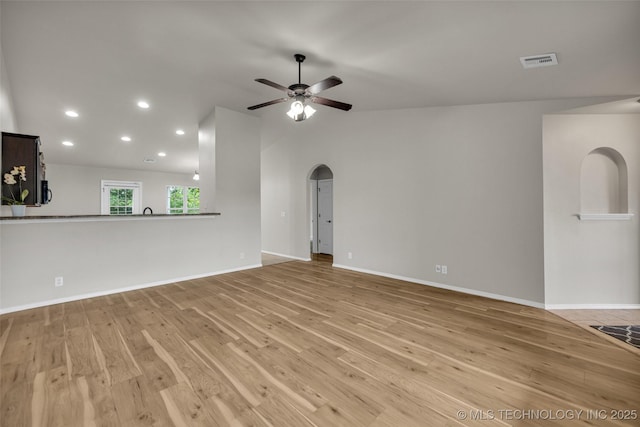 9220 S 256th E Ave, Broken Arrow, OK 74014 - unfurnished living room featuring light wood-style floors, arched walkways, a ceiling fan, recessed lighting, and baseboards