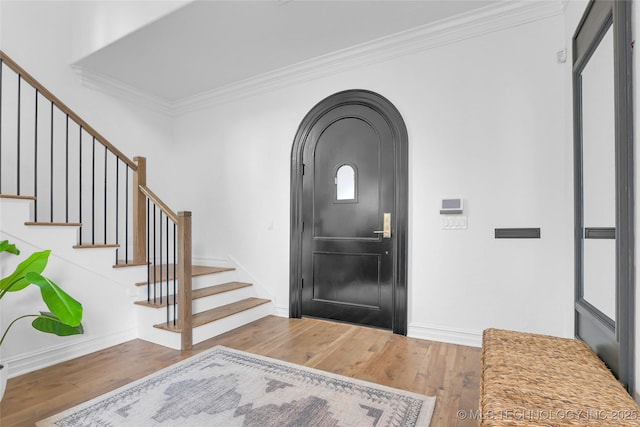 3121 S Rockford Dr, Tulsa, OK 74105 - foyer entrance with wood finished floors, crown molding, stairway, baseboards, and arched walkways