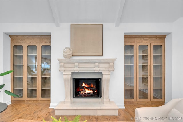 3121 S Rockford Dr, Tulsa, OK 74105 - living room featuring beamed ceiling, wood finished floors, a lit fireplace, and baseboards
