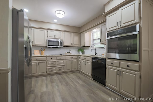 2604 W Broadway St, Broken Arrow, OK 74012 - kitchen featuring black appliances, a sink, light wood-style flooring, decorative backsplash, and light stone countertops