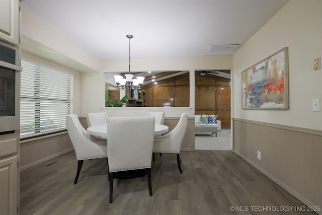 2604 W Broadway St, Broken Arrow, OK 74012 - dining area with dark wood-style floors, a chandelier, baseboards, wooden walls, and a wainscoted wall