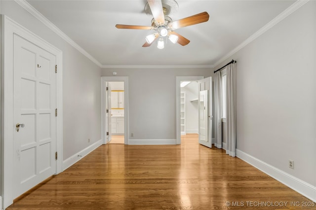 2508 Terwilleger Blvd, Tulsa, OK 74114 - unfurnished bedroom with wood finished floors, baseboards, a closet, a spacious closet, and crown molding