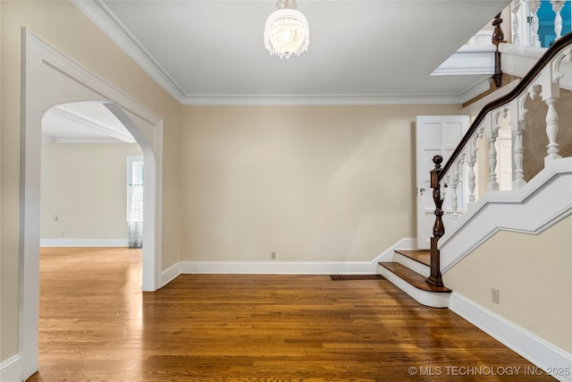 2508 Terwilleger Blvd, Tulsa, OK 74114 - entryway with arched walkways, wood finished floors, stairs, crown molding, and a chandelier